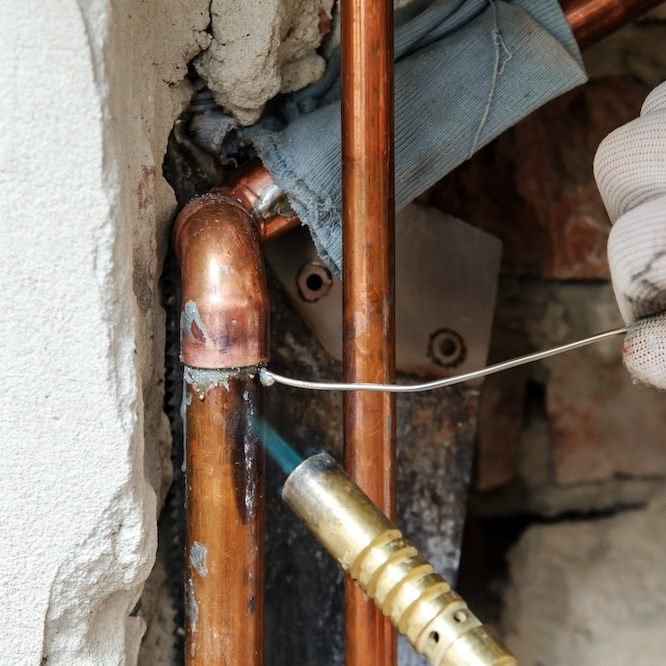 Copper pipes being melded into place.